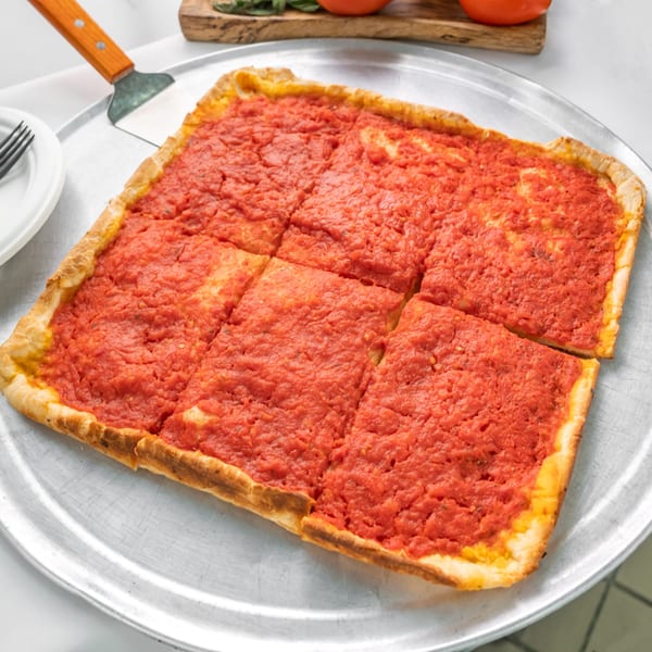 Allegro Pizza's square Sicilian pizza with thick crust and rich red tomato sauce, sliced on a metal tray.