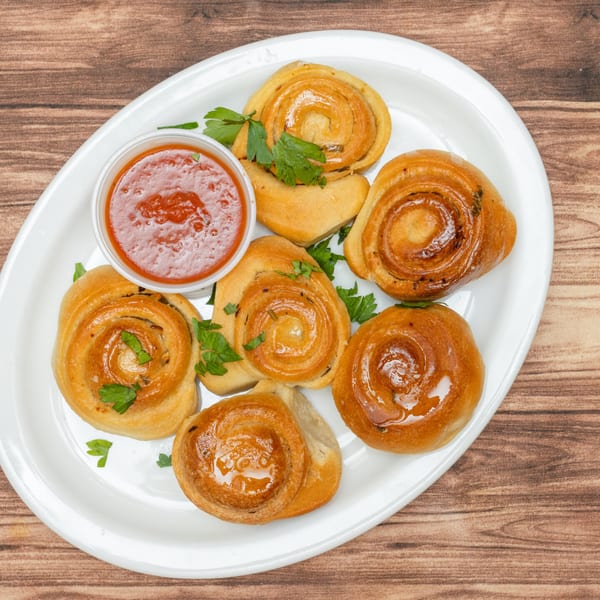 Allegro Pizza's golden-brown garlic knots with parsley and a side of marinara sauce.